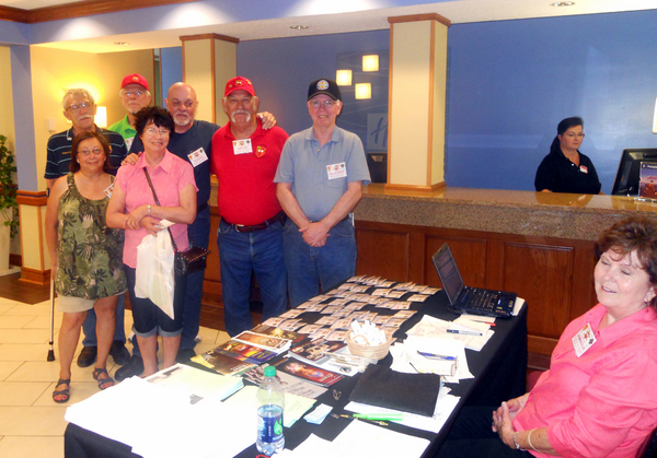 Reunion Photos - Jerry Orr
Registration Day finally arrives!  We showed up on Thursday at Bldg 5676 to register and get a room.  The building was formerly one of the hi-rise BOQs of the 60s, now part of the Holiday Inn Express chain.  L to R: M/M John Severn, M/M Bill Kull, John "Moon" Mullins (back), Cowboy Danny Fort, and Edward Mahoney.  At the desk is Barbara Moeller, handling the paperwork.
