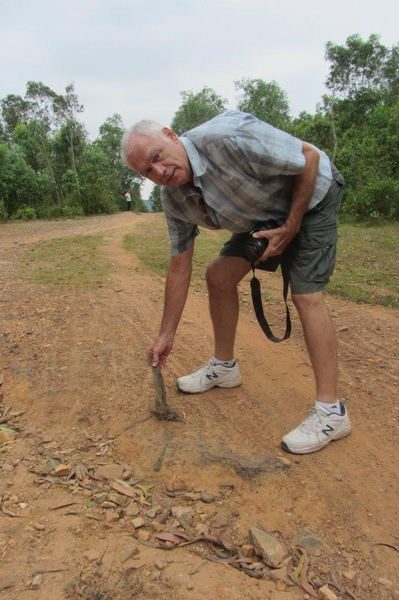 Back in Nam again
Danny is walking along the road in the former LZ Uplift area and is picking up a piece of a sandbag in the roadway.
