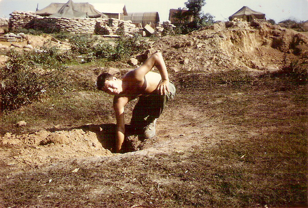 LZ Baldy - Mortar Attack
SP5 Jim Fitzpatrick and one of the many mortar & rocket holes taken near our tent (our tent is the pointed one...out of the rear of the tent is our bunker.  During the first attack, we found our bunker was open on the back side, which was where the rounds were landing.  We sat there listening to the rounds coming overhead enroute to the CP bunker.
