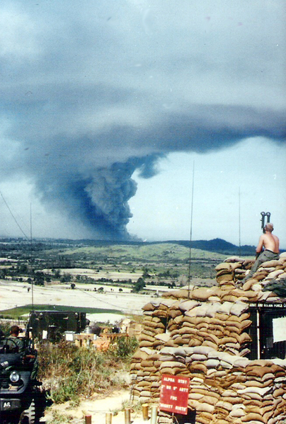 Free Fireworks Display - Summer, 1967  Duc Pho
Lt Dennis Munden peers thru the BC scope set atop the sandbagged CONEX container that serves as the "A" Btry FDC at LZ OD directly across from LZ Montezuma, the 3rd Bde HQ at Duc Pho.
