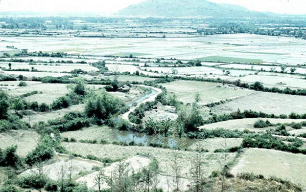 LZ OD - Flooding the paddies
Almost totally unfazed by the surrounding hostilities, the rice farmers flood their fields.  A clear view (looking south) from LZ OD to LZ Montezuma / Bronco in the distance.  The rice paddies were worked every day.  We had no road transportation out of LZ OD.  You had to fly or walk.
