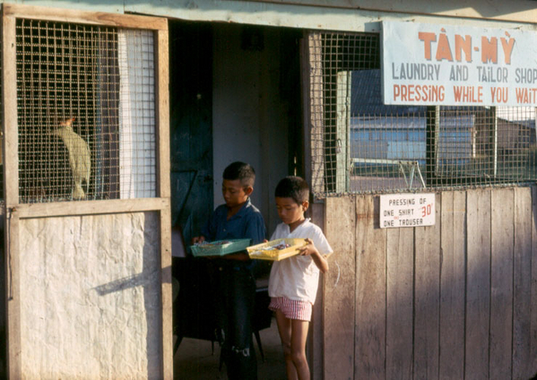 Streets of Saigon
Kids selling American candy bars in the door of a Vietnamese laundry...just one of the many strange sights in a strange land.
