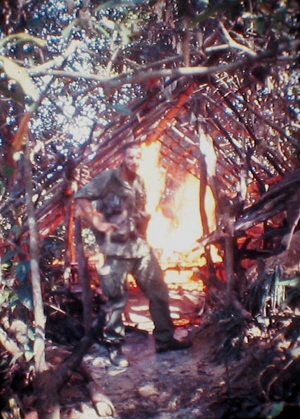 Lt Keith stands in front of a burning hooch.  Many hooches in Nam met their fate at the hands of a torch.
