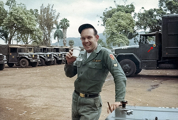 Typical Motor Pool
Not sure if Sp4 Jerry Chastian went over on Operation Blue Light or not. Jerry was from Evansville, IN.  He is the classic motor pool guy...hat kicked back, cigar, and cuppa coffee.  Note the red arrow pointing to the 2/9th Arty emblem used on its assigned vehicles as well as the OD fatigues we wore back in 1965.
