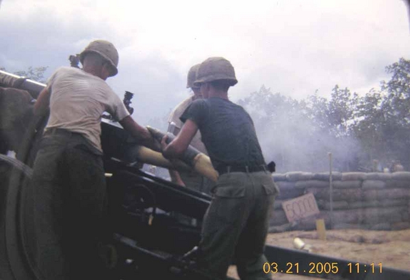 FDC tries out the guns
That's me holding the 105mm round for loading into the breech.  The gun-bunnies said I was "too slow" and suggested I return to the FDC.  We were celebrating the 50,000th round...note the sign in the background against the sandbags.
