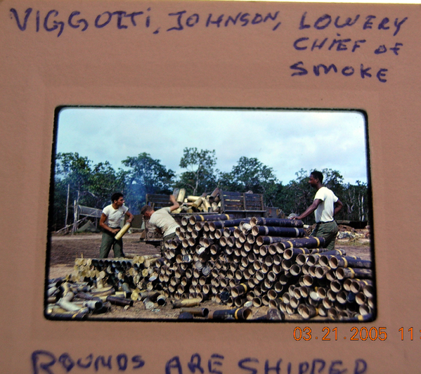 Stack 'em up
L to R: PFC Vincent Vigilotti, PFC Douglas C. Johnson stack up the empty tubes from the 105mm ammo as SFC Therman L. Lowery (Chief of Firing Battery) who replaced "First Shirt" 1stSgt Johnnie Winston,  does the hard job of supervising.
