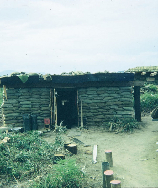 Enlisted FDC Bunker
Several items of interest here: the neatly stacked sandbags, the pickaxe, the water cans and wash basin, and canteen cups hanging off the roof.  Note there is a DOOR on this bunker!  Now that's civilized!
