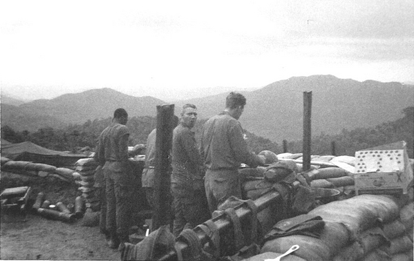 No Dining Room chairs
It's standing room only at a typical gun section chow time.  Taken at LZ Corral, March, 1967.  L to R: PFC Johnson, PFC Hourigan, and  Cpl John Kuntz.
