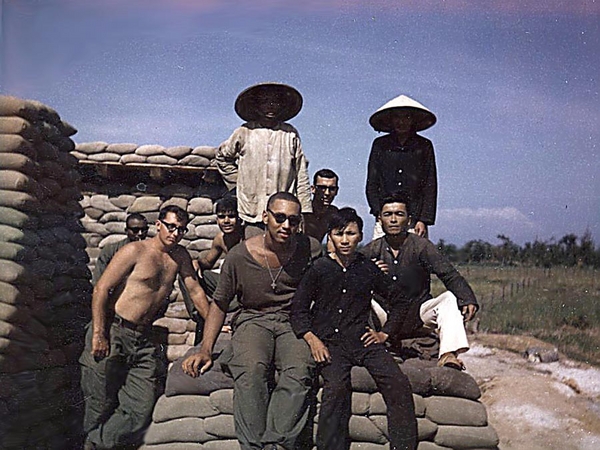 Work Crew
My work crew.  We completed a new perimeter bunker at Duc Pho... a WELCOME improvement and 100% safer than what we had in the early days! Taken with a Polaroid on a self-timer. Not bad, huh? The boy next to me was one of two kids (a boy and a girl) I adopted from a local orphanage. We had a program where we could adopt orphaned kids and contribute something to their care each month.  There were four Vietnamese helping us build this big bunker and they are all in this photo. The guy just over my shoulder to the left side of the photo was Roman (not sure if the same Roman listed on your site). The fellow behind me and in between the two Vietnamese was from Philadelphia... and I must say I cannot remember his name because we always called him "Philly" anyway!  The other two GIs on the left are UNK (names forgotten).


