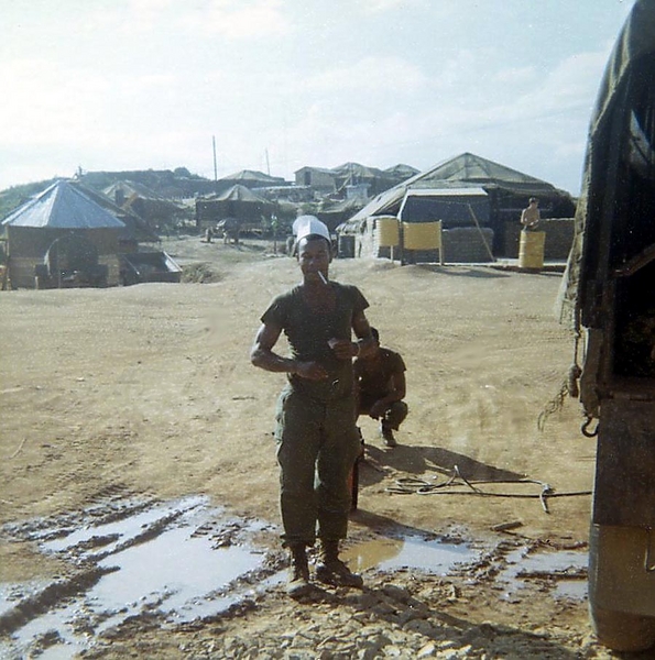 PFC Charles Lovelady
(Duc Pho) Here is Charles Lovelady of Detroit in his mess cap. This is the FRONT side of the mess tent where smoking was allowed! Cpl. Money wisely didn't allow smoking on the rear side since we had so many gas/kerosene cans stored back there to fuel the stoves! That little hexagonal tent on a kit base behind Lovelady (to the left) served as our barber shop and the fellow who ran it was named Craig Lash. You had to make appointments to get your hair cut and there was always someone in there. Lash was from San Francisco. 
