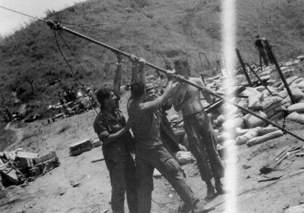 Re-visiting Iwo Jima?
The FDC crew was attempting to be clever in duplicating the flag-raising on Iwo Jima.  It was actually the raising of a R-292 antenna.  Can't communicate without it.  Smiling Greg Malnar on the left leading the event.  Great place for a sniper on the hill behind.  We did not stay there long enough for anyone to figure that out thankfully.
