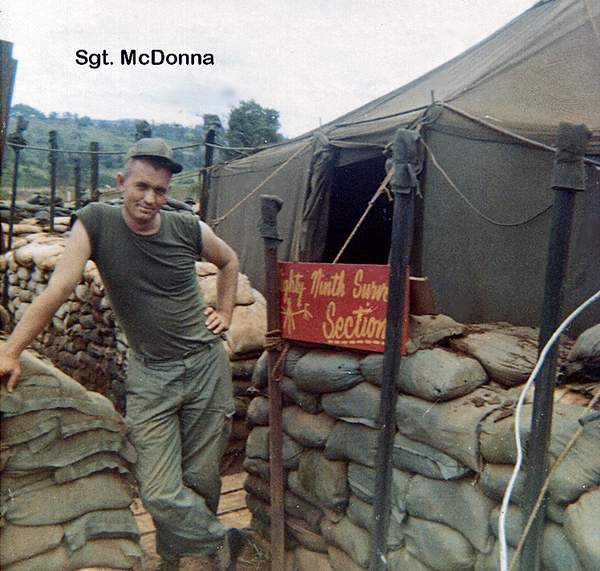 Survey Section
Sgt McDonna poses proudly next to the Section sign.  The sign says "Mighty Ninth Survey Section" when photo is enlarged.  Wonder where that piece of history is today?  Engineer stakes prop up the sandbag wall around the tent.
