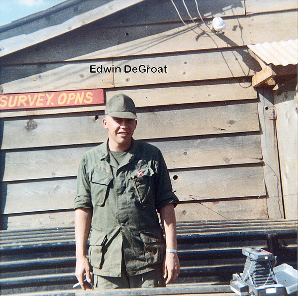 Survey Operations
Sp4 Edwin DeGroat stands in front of the "Survey Opns" building.  Note the bellows-type camera in the foreground.
