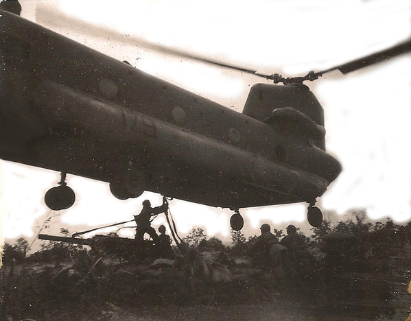 Hooking up the CH-47
Exciting task.  Who wants to do it?  Well, here's Sp5 Clint Curry volunteering to get under the mechanical beast.  My notes indicate Clint was hooking up the howitzer for a hip shoot on LZ Cathy as it lifted off in Sept, 1969.  The Advance Party discovered the proposed LZ wasn't ready and they used up all our C-4 cooking supplies to blow down trees.  I still remember the lousy smell of those heat tabs....ugh.
