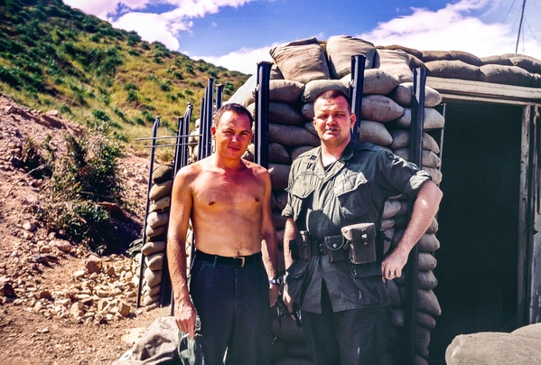 OIC
Captain Howard "Dutch" Hutsell stands outside a bunker with a soldier getting a Nam suntan. 

Dutch was on the Battalion Staff as the S-4 and was later the Battery Commander for "A" Battery.  Originally from Arkansas, he deceased in 2019.
