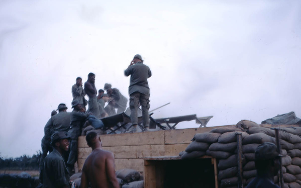 Fire!
A military cot blocks the view of whatever is being fired, but this photo proves conclusively...without any doubt...that our combat brothers DID NOT use ear plugs?  Eh? What's that?  I'm entitled to VA hearing disability?  Ya think?
