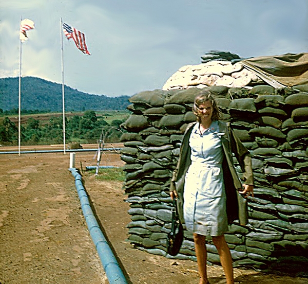 There she is!
Our wonderful  Donut Dolly, Ms Jenny Young.  Thank you so much, Jenny!   Jenny opens her raincoat to show that it wasn't long enough to prevent her dress from getting soaked.  This photo taken at LZ St George as best she can recall.
