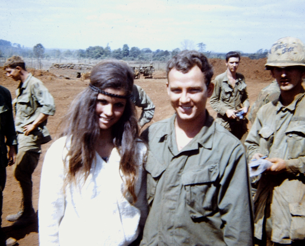 LZ Lois - Christmas, 1969
"Cruit", center of photo, always wore his airborne wings.  Came to the battery from the infantry as a gun bunny, wanted to be FDC and we were getting really short so he came onboard.  I captioned this on the slide as "Cruit finds a girl his own size".  No matter how much we picked on him, Cruit was always smiling and happy-go-lucky.

Note the "hippie" headband and long, straight hair on the chick.  Boy, we didn't know what was waiting down the road for us, eh?
