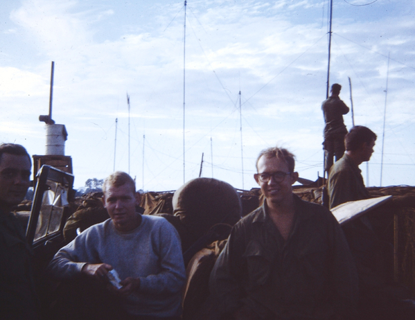 LZ Lois - FDC Area
L to R: Far left, can't make him out; next is Lt Harry Baumgartner (Lt Richard L. Baumgartner).  For some reason, he was nicknamed "Black Bart" - probably because of the attempted moustache.  Then Sp4 Jim Hurdle, Carl from Georgia, and in the background is PFC William ("Nan The Man"), aka "PigPen" Nankervis (deceased).  He is probably dreaming about the World and returning to be the left bank cylinder man at Ford's East Lansing plant.
