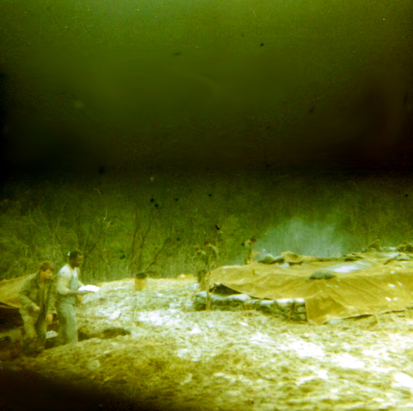 LZ Tuffy - 1970  Breakfast coming up
Gotta love the Army's massive tail, they know just what the tooth needs.  Carl and (I think) the Chief picking up rations - raw eggs.  They sent us thousands of raw eggs.  Just what you need when you can't get a fire going and there is nothing larger than a canteen cup to cook in.  Unfortunately Jim Hurdle's stainless steel pot went back to the World with him.  Necessity is truly a mother, excess powder bags burn and helmets hold water.  Soft boiled or hard?
