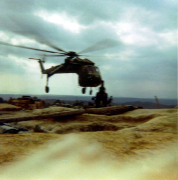 LZ Tuffy - 1970
The Sikorsky Skycrane unloads a huge log, almost as long as the LZ.  Many hooches used it as a foundation.
