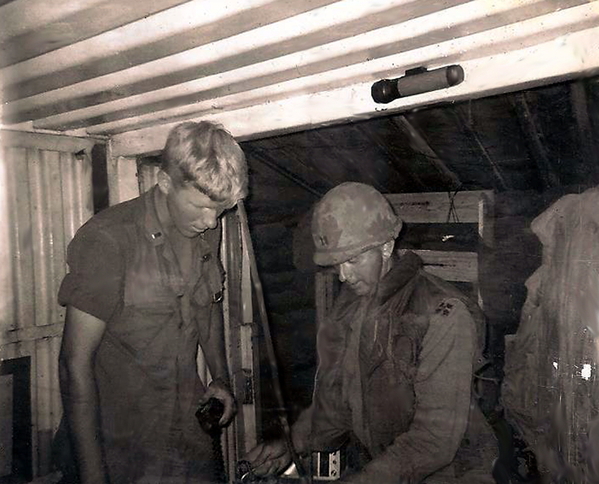 Lt Jim McHugh and BC Capt Richardson
Lt McHugh, XO, and BC Richardson inside the FDC CONEX.  I recall that McHugh's dad was a full bird colonel.  He started college at VMI and dropped out first year and went through OCS.  He was a 20 year-old 1st LT as XO. Really a great kid (I was 23).   Between the two of us we could do a high burst registration, which helped keep me around.  He knew his stuff, but we loved to fool around with him. He wanted to fire the battery in strict accordance with the FM6-40, but FDC was more conscious of potential "check-fire" situations. We got the section chiefs on the guns to go along with us, so rather than argue with him we just said "yes sir".  So the next thing is McHugh: "Battery" then the Chiefs:"Platoons", McHugh: "fire" followed by a ragged  "bang . . . bang bang . . . bang . . bang (we only had 5 tubes at the time).  He came into FDC and we offered to show him how to do it.  Chief: "Battery ready", Me: "Battery fire" BANG in perfect unison.    
(Note. Lt McKugh died on December 8, 2017 from cancer.)
