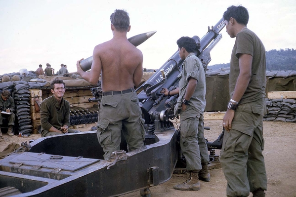 Gun Crew in action
Here is the M-102 in all its glory.  The older vets remember putting the M1A101 to work in 66-67. Note the attire: woolen shirt due to nightime temperature drops, bare back for the hot days, fatigue shirt and OD tee shirt.  Yep...that about covers it!

L to R: PFC Mike Steele, SP4 Rick Satterfield, PFC Tony Heredia, and PFC Richard Sanchez.
